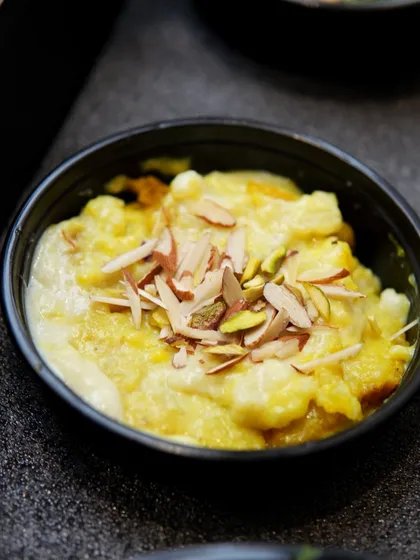 A close-up of our Pav Halwa, a rich and comforting dessert topped with sliced almonds.
