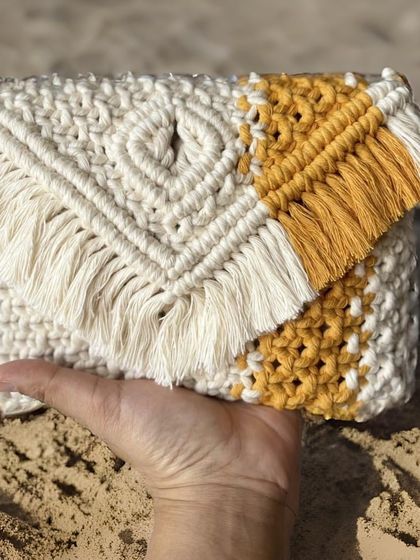 I love mixing colors! This clutch combines natural off-white with a splash of sunny yellow. The heart detail in the knotting and the fringe make it a truly unique accessory.