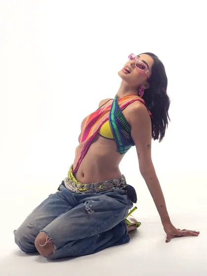 A full-body shot showing the complete look with ripped jeans and a scarf top. It’s all about mixing different styles to create something unique.