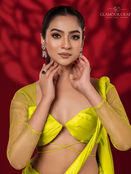 A modern and confident portrait. The vibrant lime yellow top contrasts beautifully with the deep red background, while the clean makeup look enhances the model's natural features.