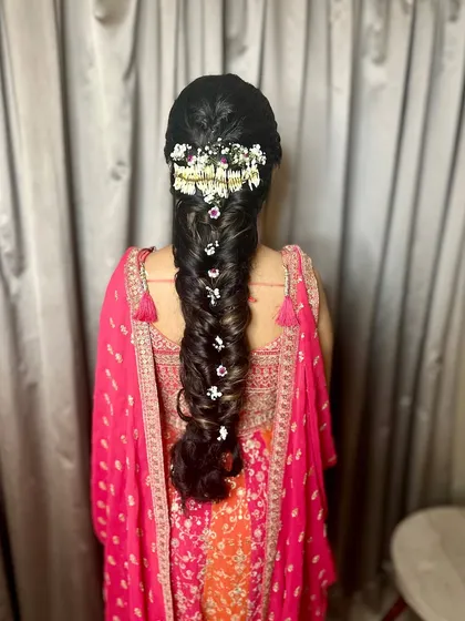 An intricate fishtail braid decorated with small flowers. This hairstyle is both glamorous and bohemian, perfect for a Mehendi.