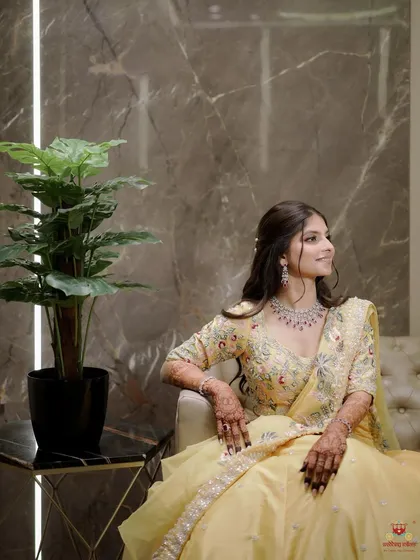 A poised and elegant shot of the bride-to-be. Her makeup in this yellow lehenga is soft yet defined, with a focus on a smooth, radiant complexion that looks incredible both on and off camera.