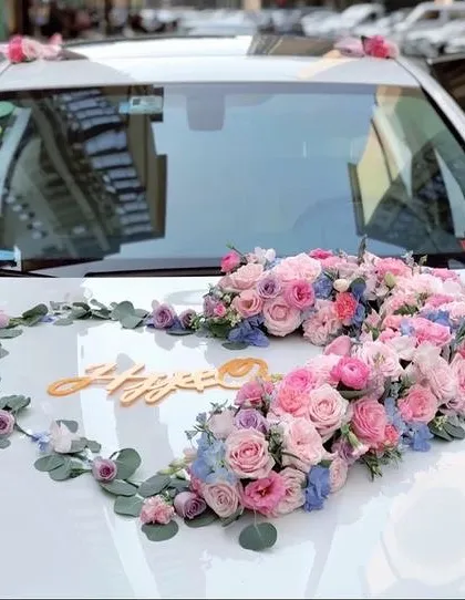 A beautiful heart-shaped floral arrangement for a wedding car. We used a mix of pink and blue roses and other delicate flowers to create a romantic decoration for the couple's getaway car.
