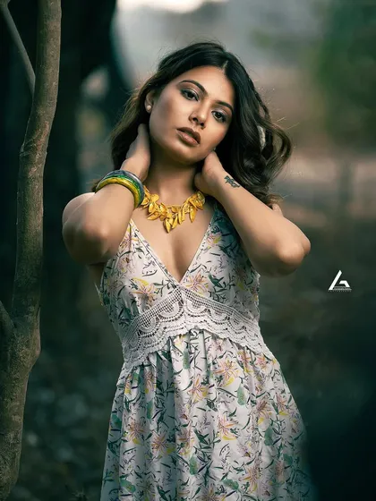 This is a classic outdoor portrait, where the shallow depth of field blurs the background and brings all the attention to the subject. The model's pose and direct gaze create a strong connection with the viewer, making it an impactful shot for a portfolio.