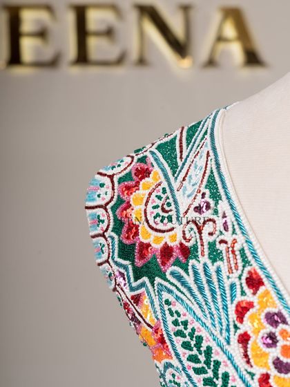 I designed this unique 'Butterfly Garden' blouse for the bride who loves color and artistry. The entire piece is covered in a vibrant mosaic of multi-colored beads and sequins, forming a stunning butterfly motif across the back.