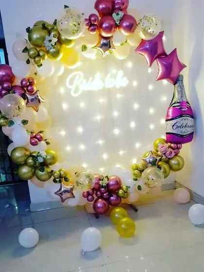 A beautiful 'Bride to be' party decoration. This ring setup includes balloons, fairy lights, a neon sign, and a champagne bottle foil balloon.