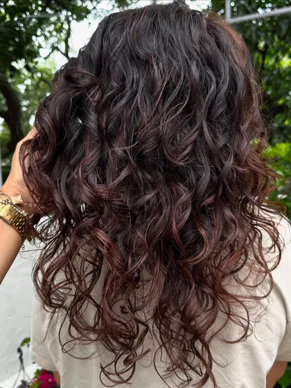 Curly and proud. I gave her curls a new life with a fresh cut, including a fringe, and subtle reddish-brown highlights to define the texture. Embracing your natural curls is always a good idea.