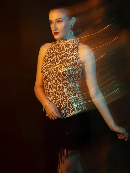 A graceful pose amidst the creative lighting. Even with experimental techniques, the focus is always on making the model look her best.