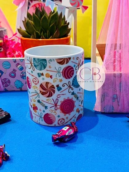A close-up of a custom-printed mug from our luxurious candy-themed first birthday return favours. The vibrant design matches the party's sweet and colourful theme perfectly.