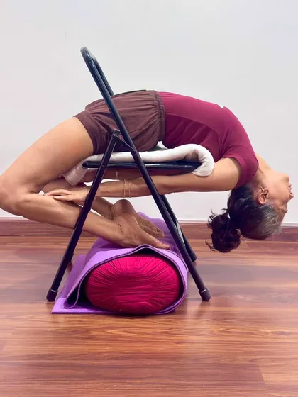I demonstrate a deep backbend, Kapotasana, using a chair for support. Props are not shortcuts; they are tools for intelligence. They allow every student, regardless of stiffness, to safely explore the full depth of an asana, opening the thoracic spine and cultivating a state of courage and receptivity.