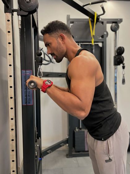 A focused moment during a tricep pushdown on the cable machine. Proper form is key to isolating the muscle and getting stronger.