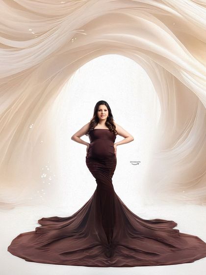 A confident pose in a fitted brown mermaid gown. The abstract, flowing background adds a modern and artistic element to this striking maternity photograph.