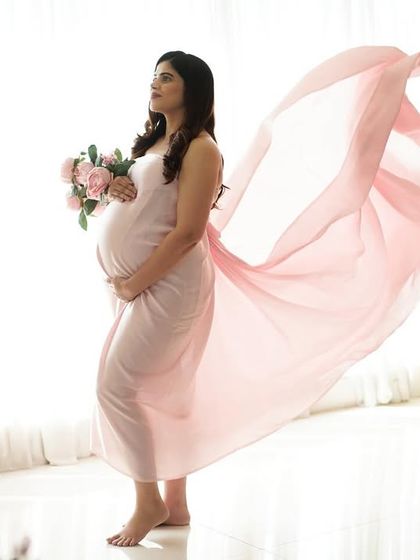 A full-length shot showing the pink fabric drape flowing in the air, adding a beautiful sense of motion.