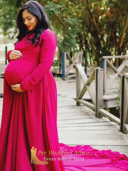 A close-up view of the magenta flying tail gown, showing its rich color and the way the fabric drapes. This rental dress is perfect for capturing both full-body and detailed shots during your pregnancy photoshoot.