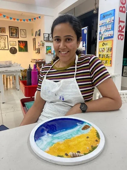 A smiling participant with her completed resin beach art. The joy of creating something beautiful with your own hands is what my workshops are all about.