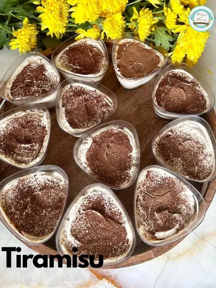 A tray of my classic Tiramisu cups, dusted with cocoa powder. I layer coffee-soaked ladyfingers with creamy mascarpone for an authentic Italian dessert experience.