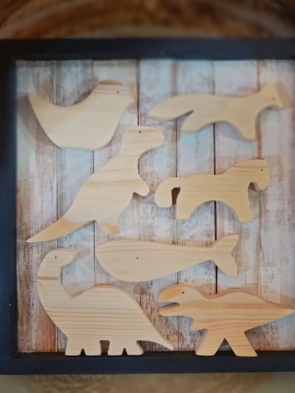 A collection of unpainted wooden animal and dinosaur cutouts, framed and ready for a creative project. These form the heart of our popular DIY art kits for kids.