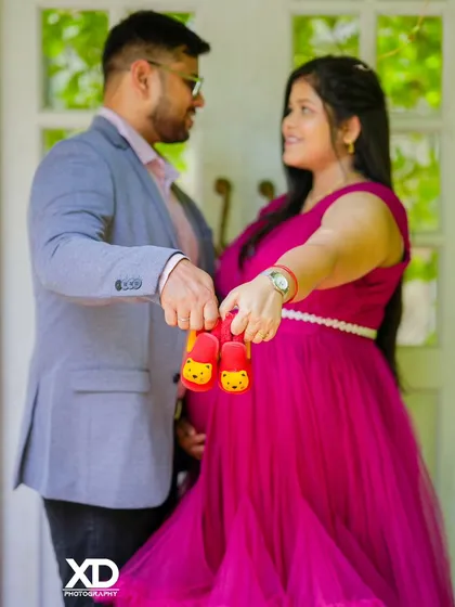 A close-up shot focusing on a pair of tiny baby shoes, held by the expectant parents as a symbol of their love.