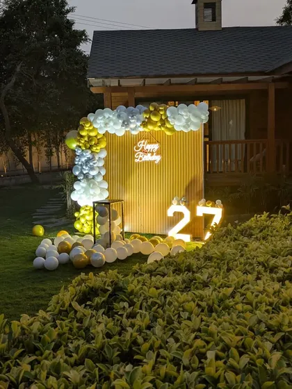 The birthday party setup seen from a distance, showing how it transforms a simple lawn into a dedicated celebration zone.