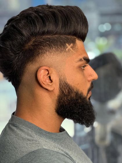 The side profile shows the perfect blend of the fade and the sharp lines of the hair tattoo.