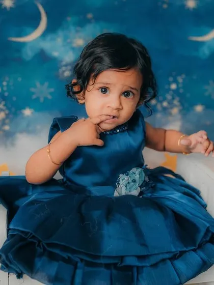 Caught in a moment of thought. The starry night theme provides a beautiful and dreamy backdrop for her first birthday photos.