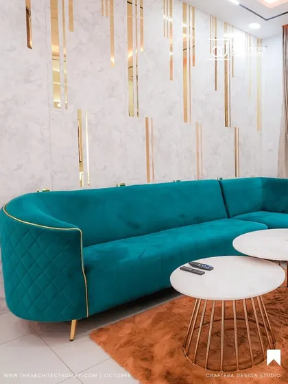 I believe furniture should be personal. I designed this custom curved sofa in a striking teal velvet, with elegant quilting and gold piping details. It sits beautifully against a feature wall, creating a living space that is both luxurious and inviting.