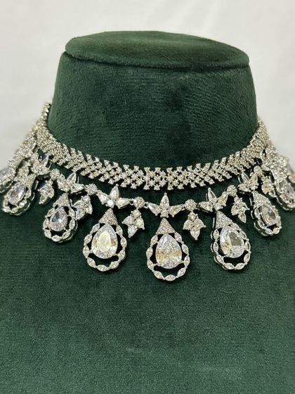 A close-up of an American diamond choker with teardrop pendants. The intricate design sparkles from every angle, making it a perfect rental for a night event.