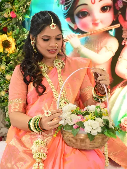 A close-up of the mom-to-be holding her floral basket. You can see the details of her floral necklace, maang tikka, and ring.