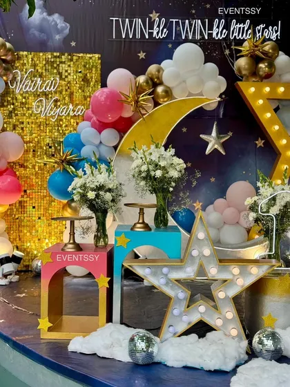 A detail shot showing the personalized names on the gold sequin wall and the fresh floral arrangements on the display stands.