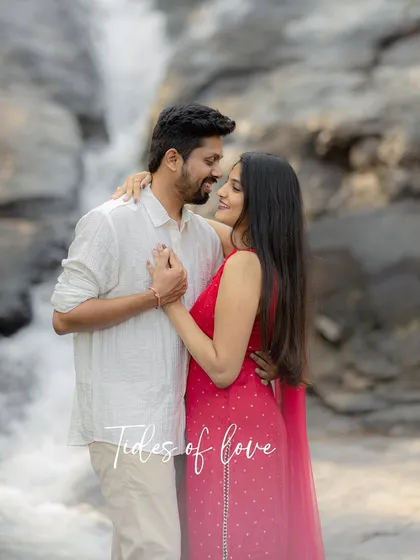 "Tides of love." A classic, romantic portrait with the waterfall as a stunning backdrop, highlighting the couple's loving gaze.