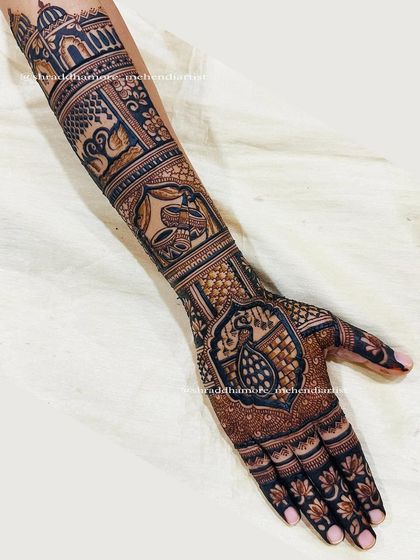 The corresponding arm to the previous design, featuring a large peacock on the palm and a swan on the forearm, topped with a palace dome.