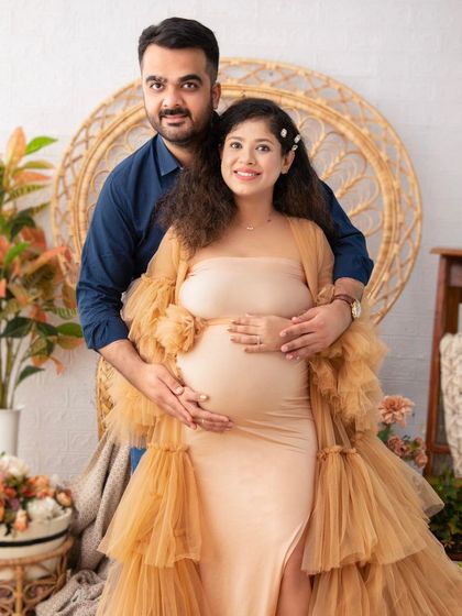 A warm and intimate portrait of the couple. The earthy tones of the setting and their clothing create a cozy, natural vibe that perfectly complements their loving embrace.