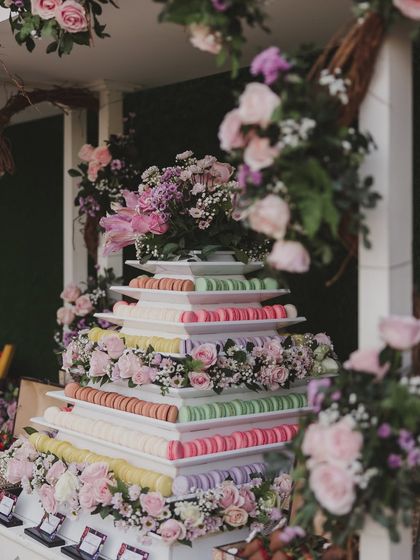 A magnificent macaron tower adorned with fresh flowers. This sweet centerpiece is a testament to our belief that every detail, including dessert, should be beautiful.