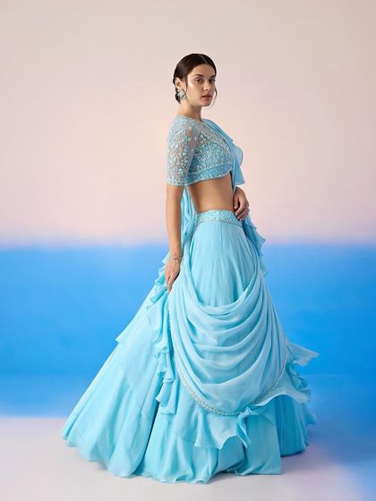 A full view of the sky blue lehenga with its draped skirt and ruffled details, a dreamy and ethereal choice.