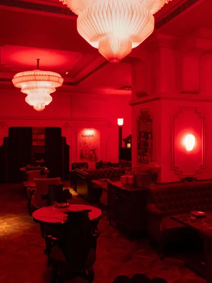 A view across the lounge area, where large, paper-like chandeliers cast a soft, diffused glow. The space is designed to feel both grand and intimate, with different zones for different moods.
