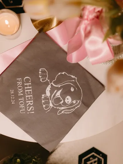 A personalized napkin from the reception, giving a "Cheers from Tofu," the couple's beloved pet.