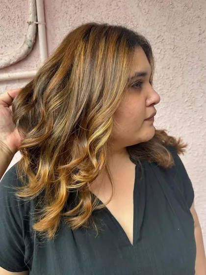 A portrait of the client with her 'Golden Hour' hair. The warm color brightens her complexion and gives her a sunny glow.