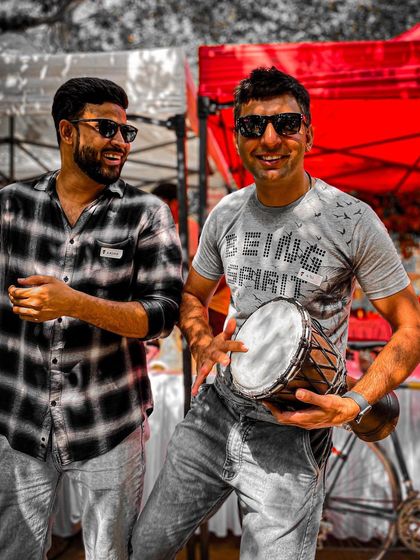Two attendees sharing a laugh while trying out the drums. The Garage Sale is all about interactive fun.