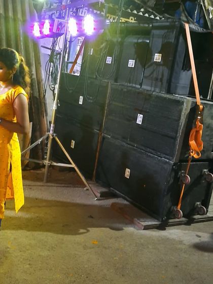 A powerful sound setup for a street event, featuring a large stack of speakers and a lighting truss. This gear is built to deliver high-impact sound in a challenging outdoor environment.