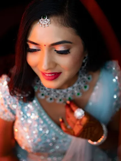 Rakshita looking down, showcasing the beautiful blend of her reception eye makeup and the sparkle of her diamond necklace.