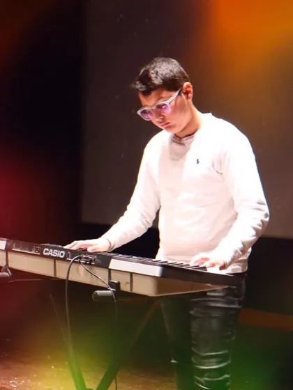 A student concentrating on his keyboard piece under the stage lights at 'Pehal'. These performance opportunities are a key part of the learning journey at my academy.