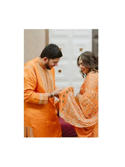 A sweet, candid moment between Hinal and Jeet during their engagement ceremony. The focus is on their interaction and joyful expressions.