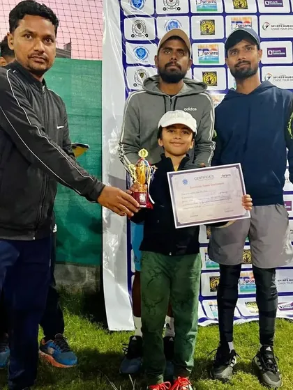 A formal moment of recognition. Here is our student Aariv being presented with his winner's trophy and certificate at a junior tennis tournament, surrounded by his coaches.