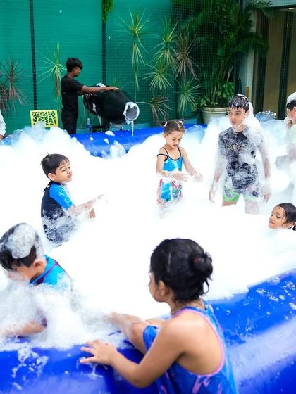 Kids completely immersed in the fun of a foam pit. It's a safe and exciting activity that always proves to be a highlight of the party.