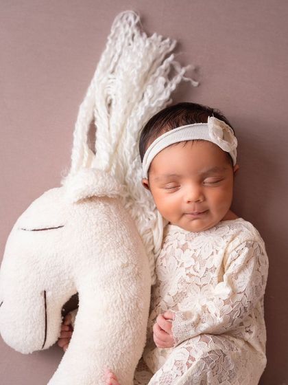 A different angle of the baby on the horse prop, showing her sweet, sleepy face.