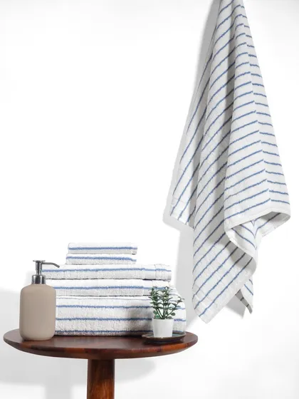 Another variation of the striped towel set. The clean white background and simple props ensure that the product's color and texture are the main focus.