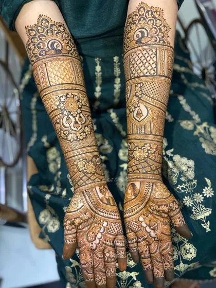 This bridal design features a mix of peacocks, bells, and intricate grid work. The patterns are beautifully balanced, creating a design that is both detailed and elegant.