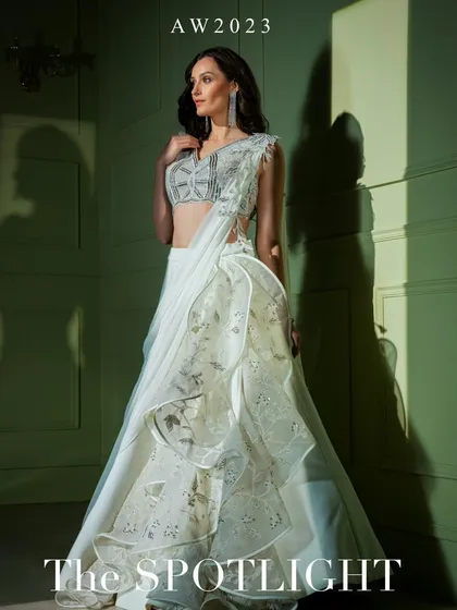 A campaign shot of the white ruffled gown from "The Spotlight" collection, a true statement of modern couture.