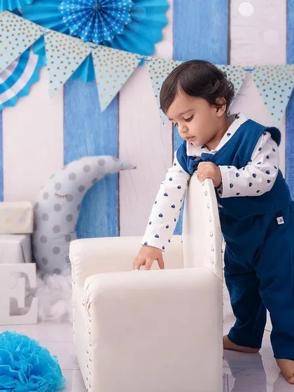 This little gentleman is exploring his birthday setup, a candid moment of a toddler on the move.