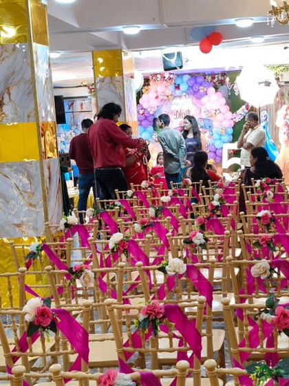 A wide view of the hall prepared for an event, showing the decorated seating area and the stage in the background.